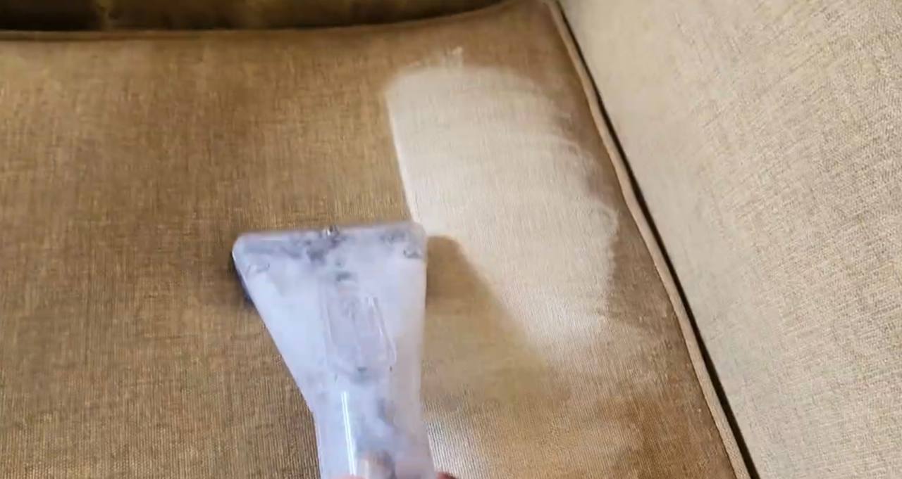 Professional couch cleaning extraction tool removing dirt from beige sofa cushion in Dublin