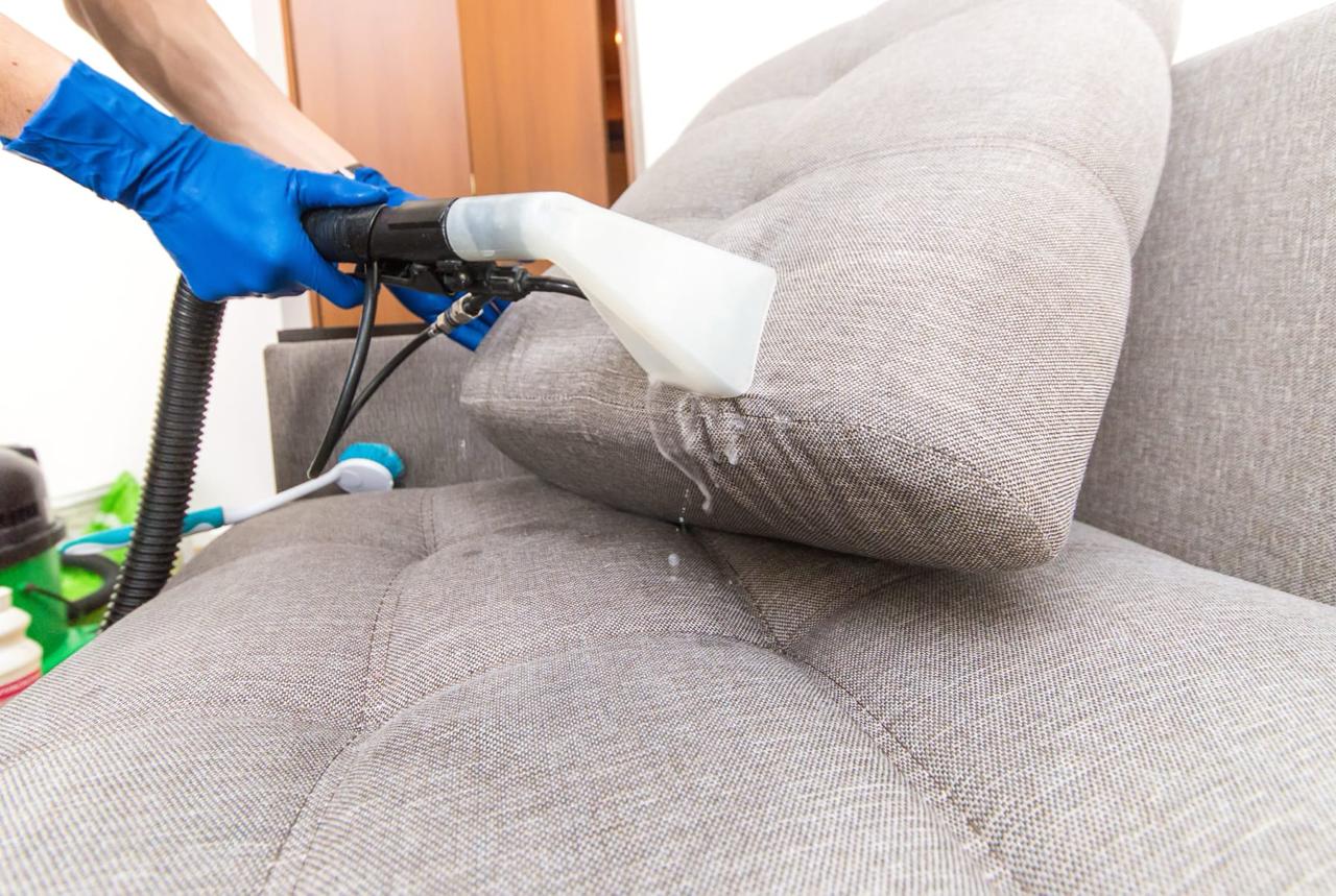 Professional sofa cleaning Dublin - extraction cleaning on grey couch with blue gloves